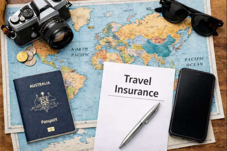 Travel insurance paperwork with Australian passport, camera, smartphone and coins on a world map flat lay
